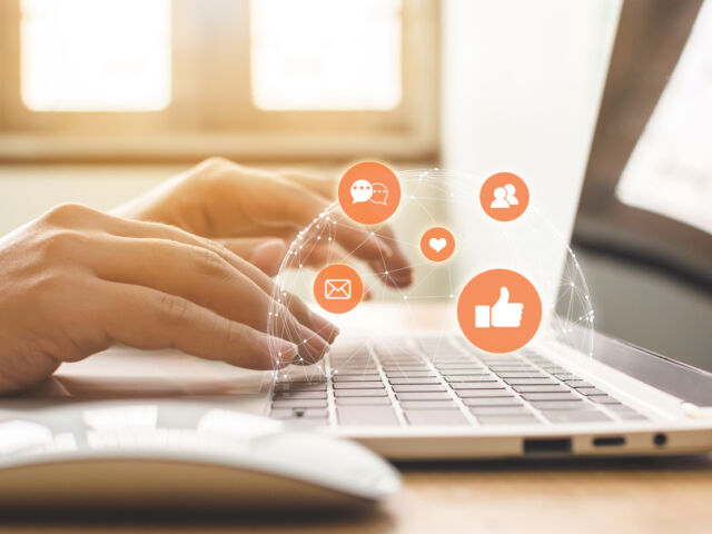 Hand of businessman using laptop with icon social media and social network. Online marketing concept